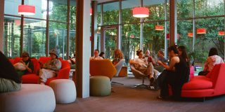 A picture of people in a library common room. Everyone is looking at their phones.