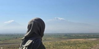A girl looking out into the distance in a field