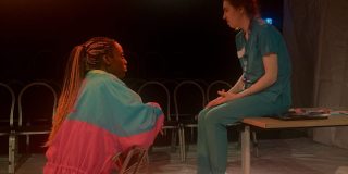 The two main characters of GREYJOY, Mina and Cait, are sat opposite one another, talking.