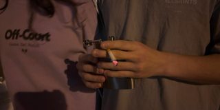 Two figures, one of them holding a cigarette