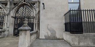 A Banksy stencil showing a judge beating a protester with a gavel on the Royal Courts of Justice in London.