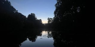 An image of Worcester College lake in low lighting, among trees